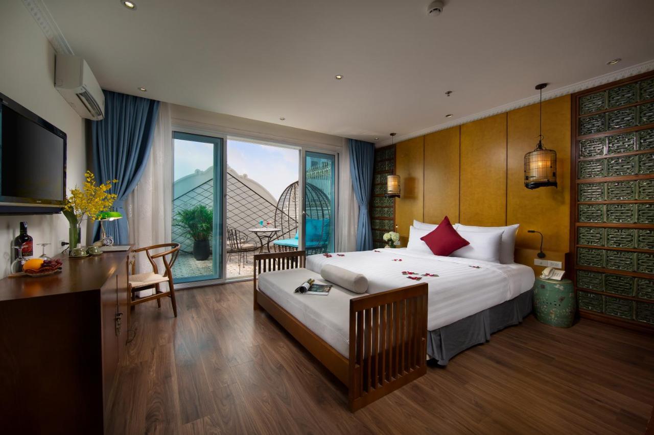 Hotel Room in Hanoi Media Hotel with Solid hard wood floors, large double bed, tv and sliding doors leading to private balcony.