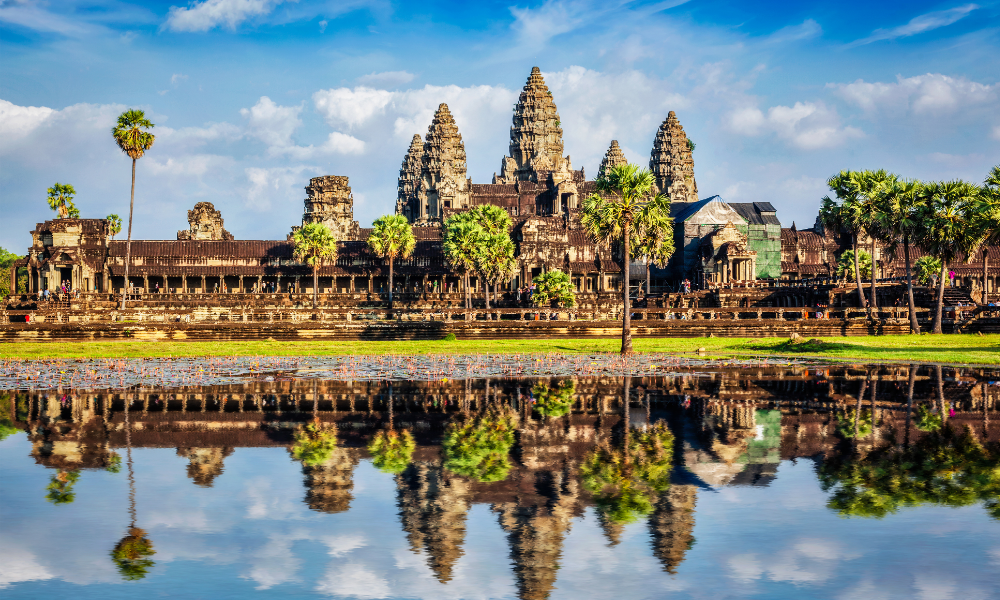 The iconic Angkor Wat temple complex in Cambodia, reflecting beautifully in the surrounding water.