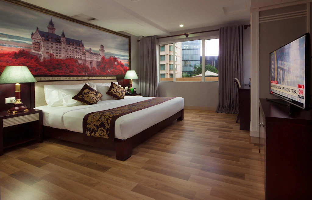 Room with large bed, wooden floors, tv and views from the window of Ho Chi Minh
